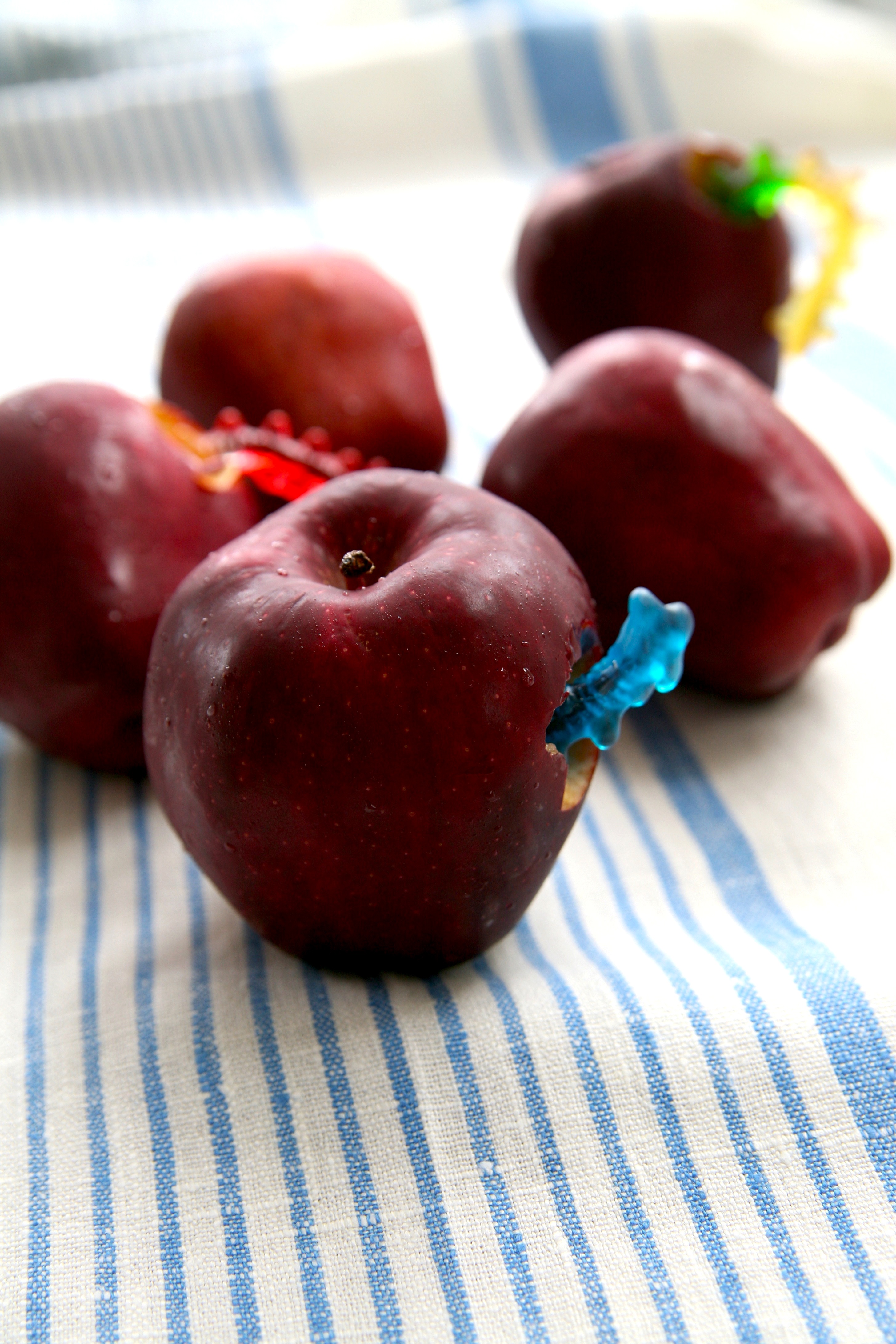 Make a slight hole into an apple and stick in a gummy worm.