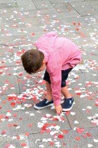 Luc picking up hearts confetti outside one of the many churches after a wedding.