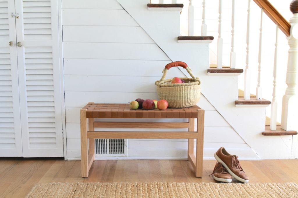 Handmade entryway bench with leather woven straps.